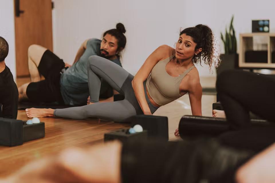 Gabby leading a studio class through a side stretch