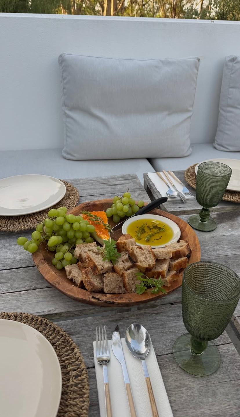 Charcuterie board with bread, cheese, and grapes on the terrace