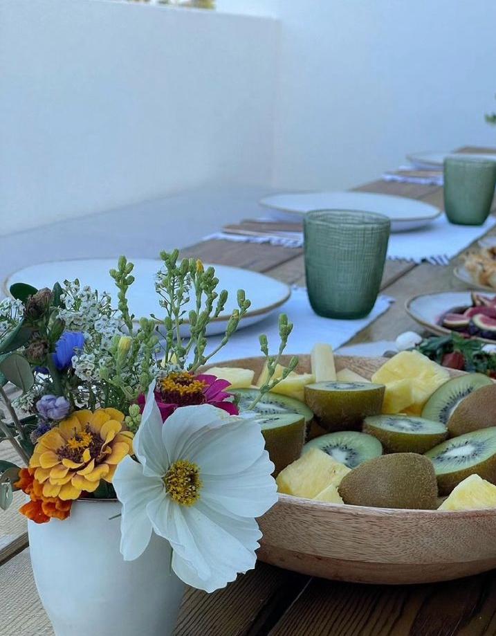 Fresh flowers and sliced fruit on the breakfast table