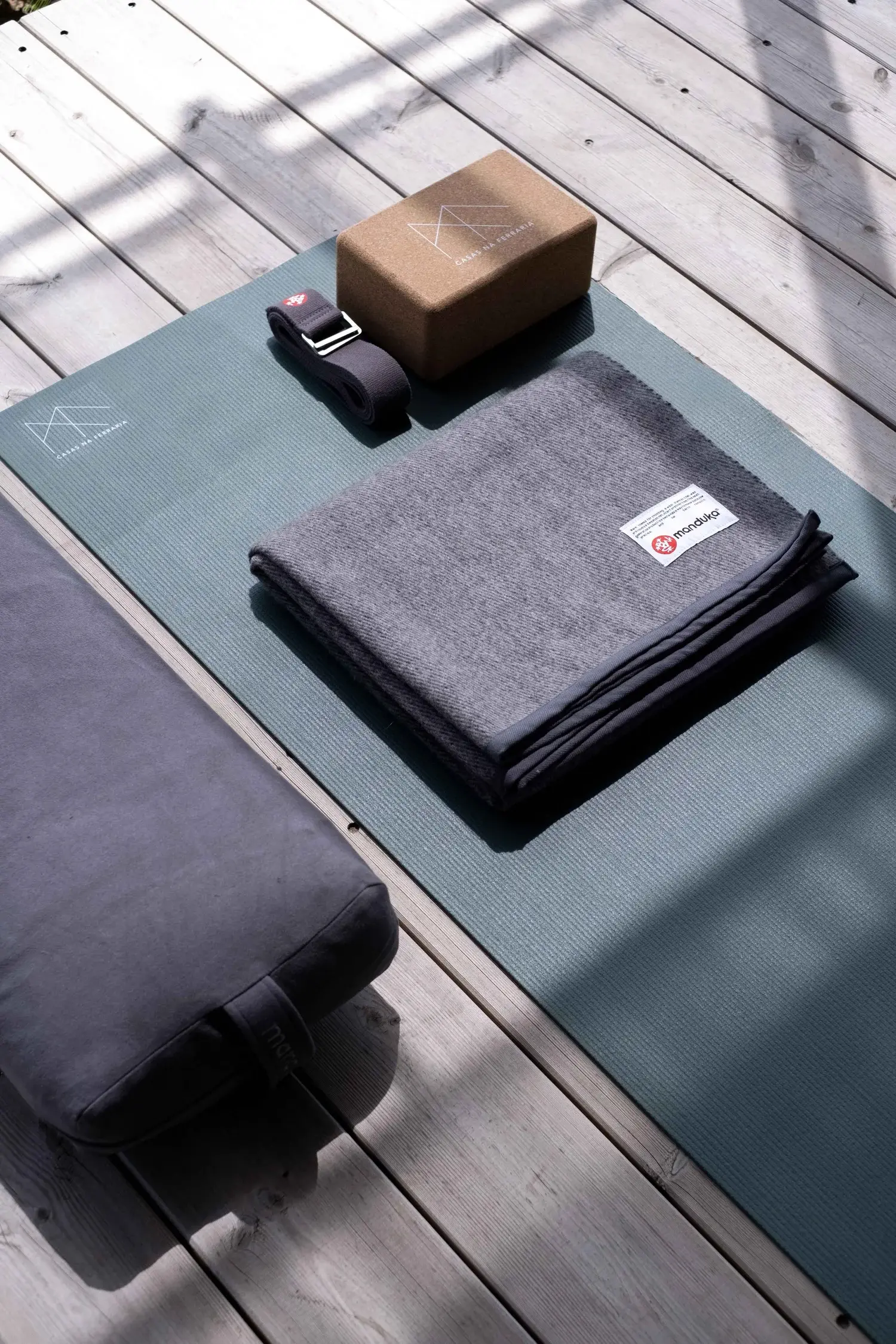 Yoga mat, block, strap, and blanket laid out for class